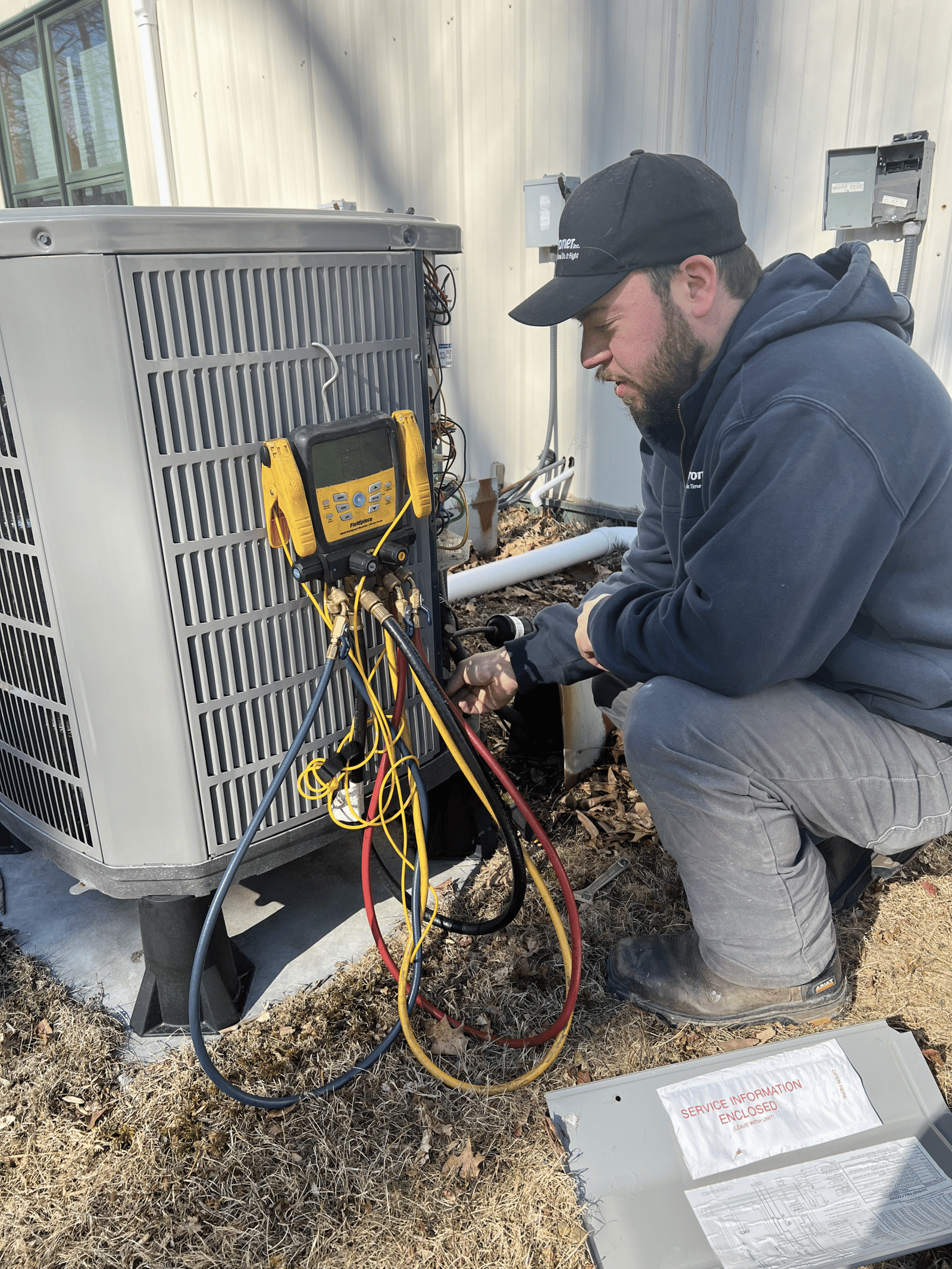 Technician servicing an outdoor air conditioning unit
