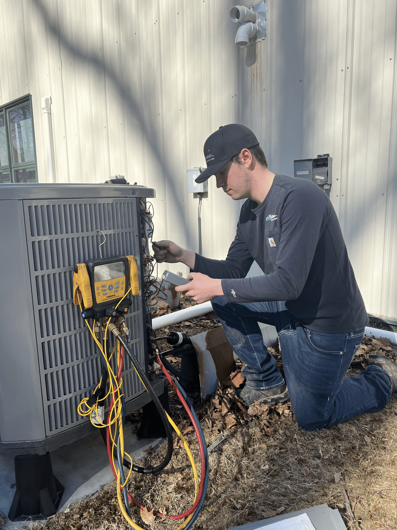 Technician servicing a heat pump for home cooling